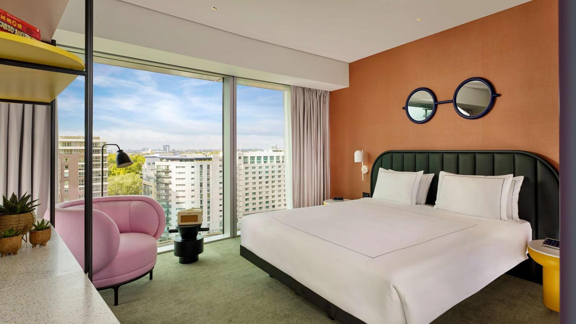 Art Zimmer mit Kingsize-Bett und Blick auf die Skyline
